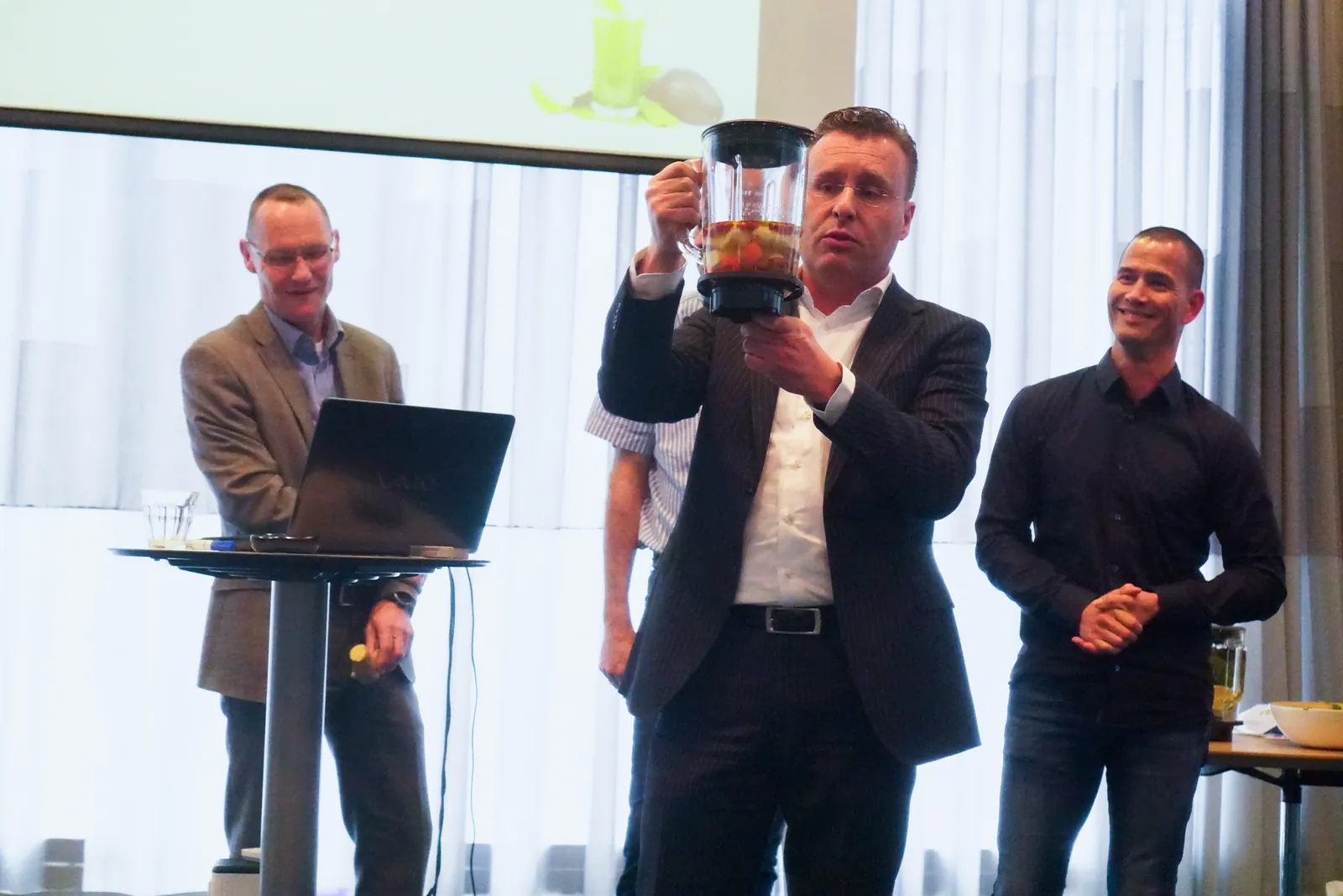 Een deelnemer presenteert trots de smoothie van zijn groep