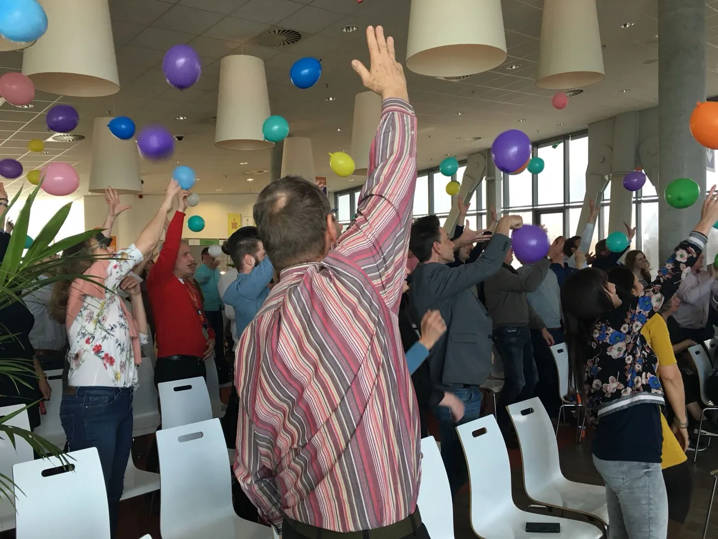 Een zaal vol enthousiaste deelnemers en ballonnen