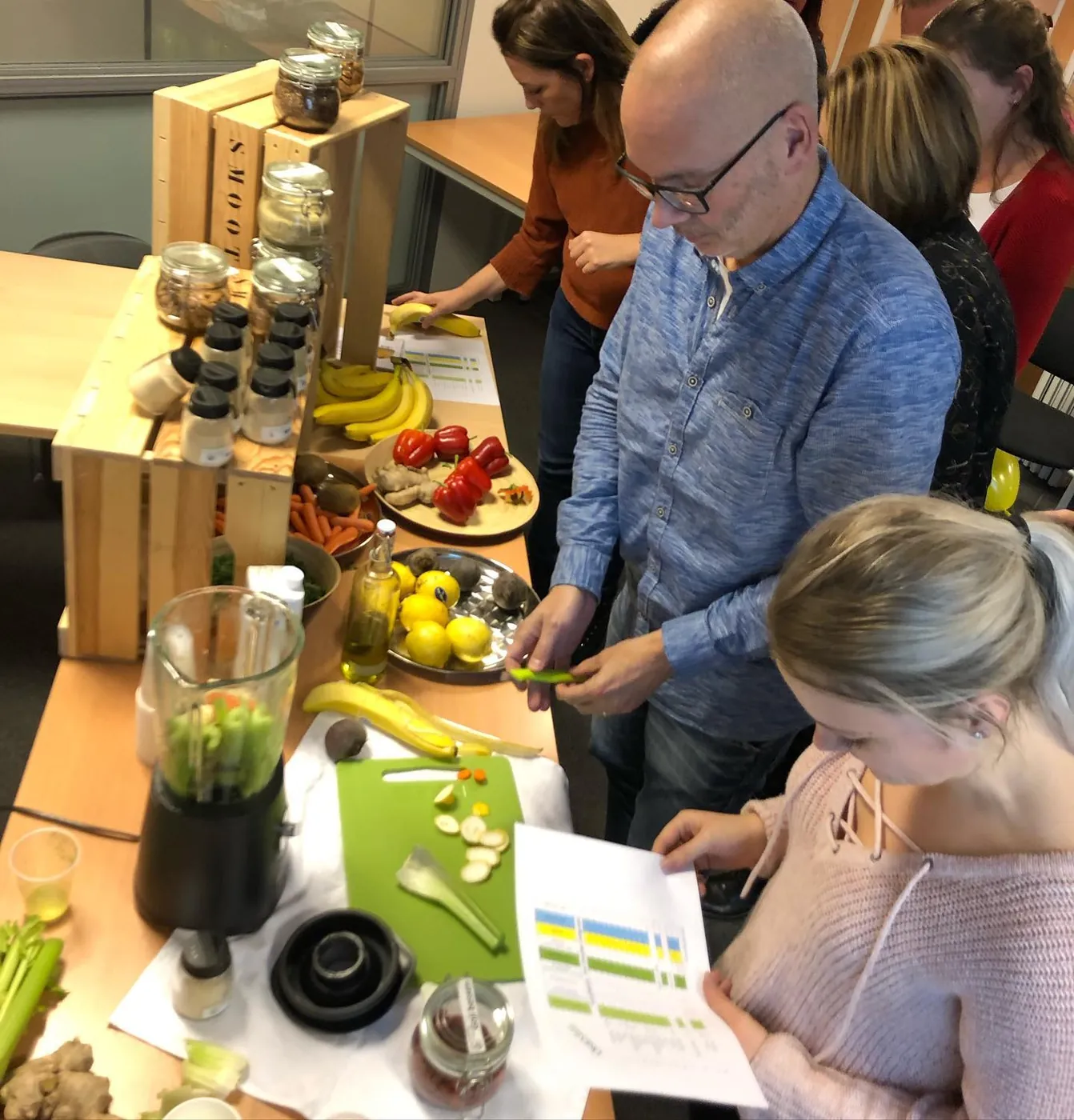 Deelnemers snijden samen groente en fruit